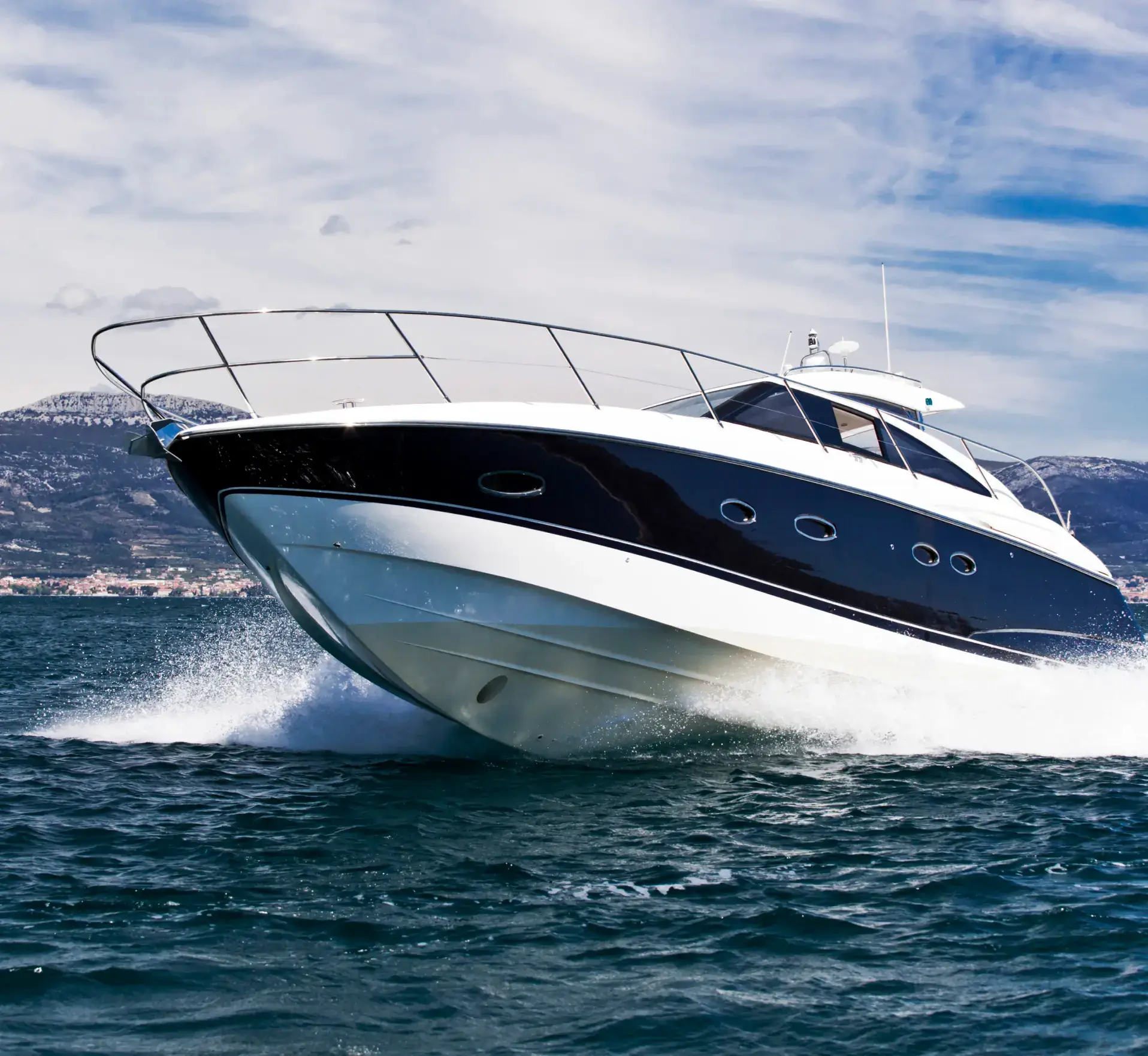 Sleek motor yacht speeding across choppy water