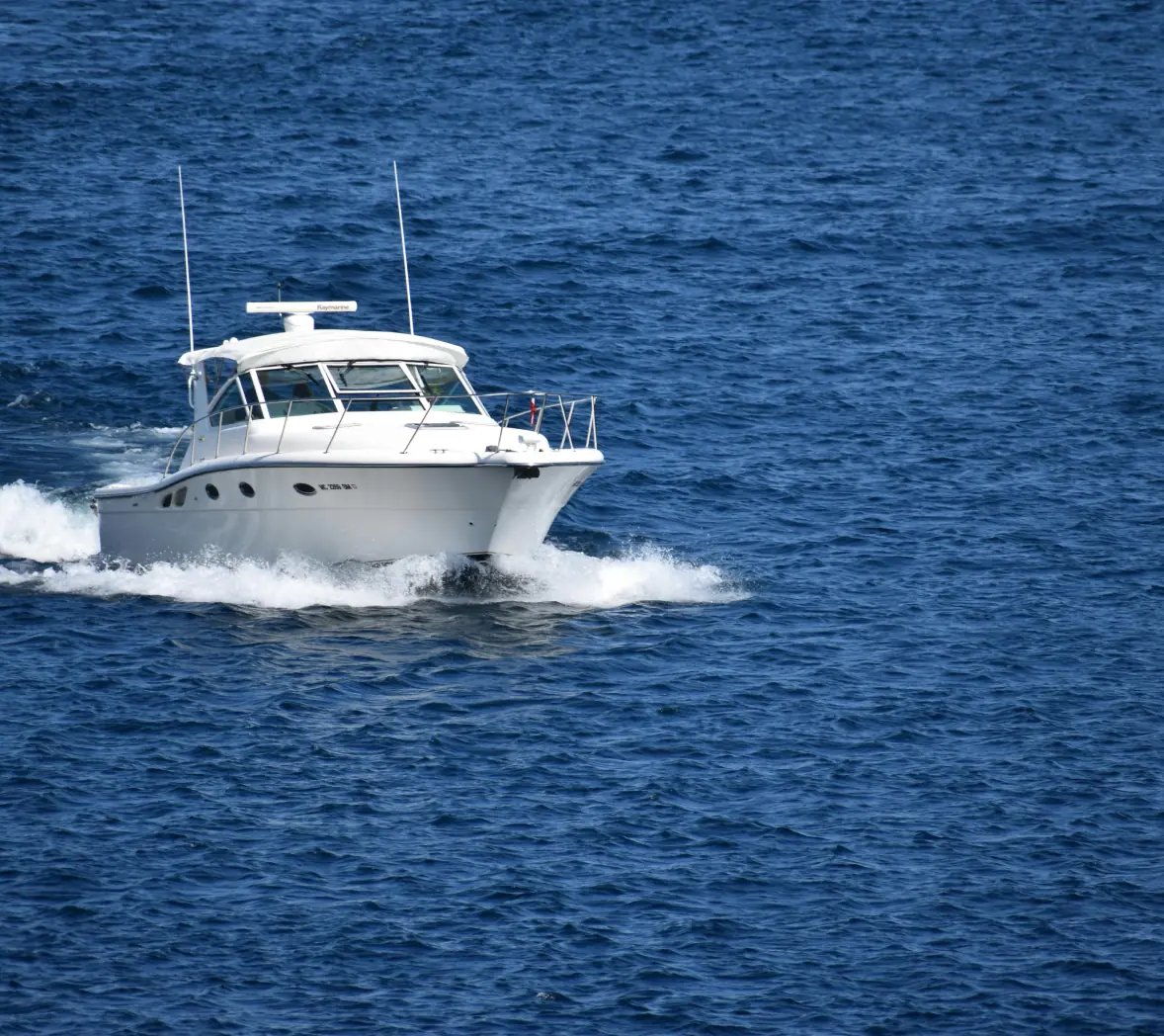 sleek white yacht cutting through blue water