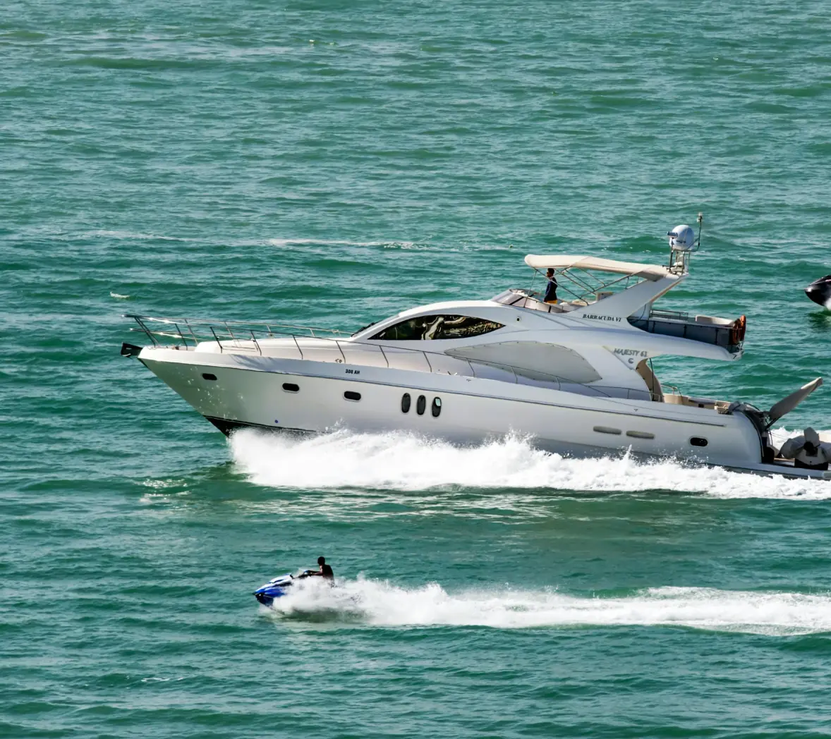 White luxury yacht with jet ski nearby
