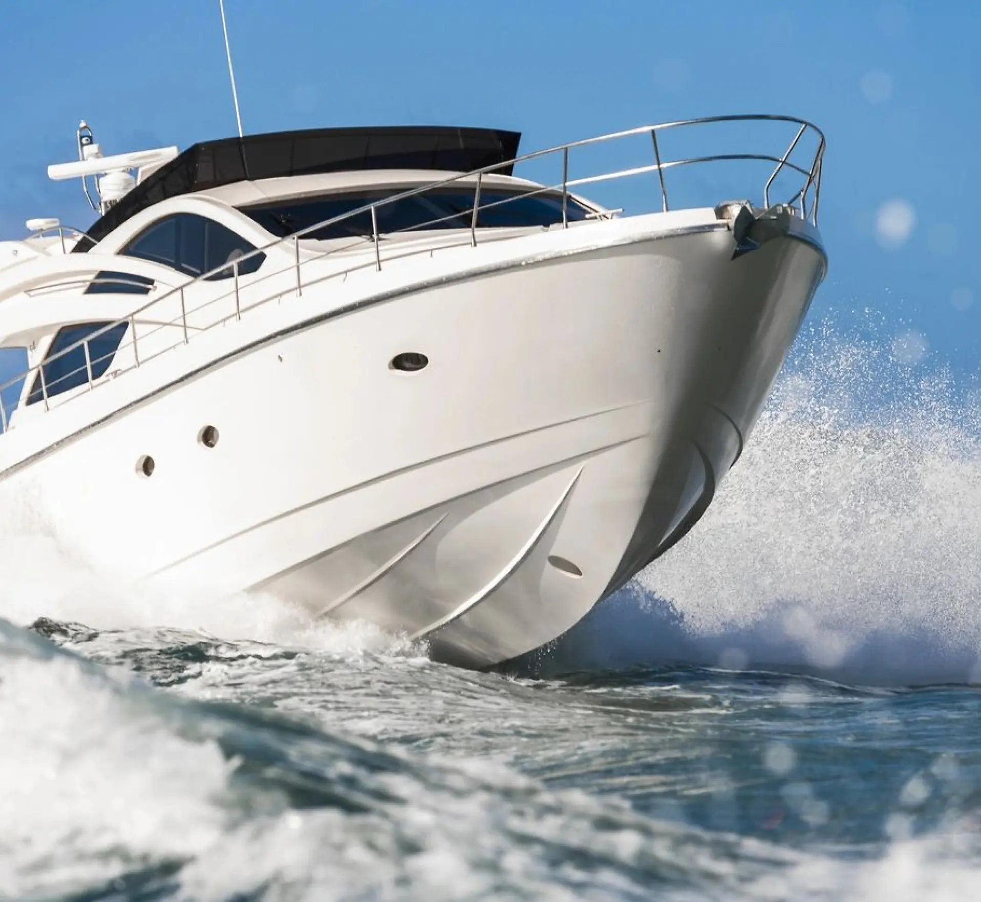 White luxury motor yacht cutting through waves