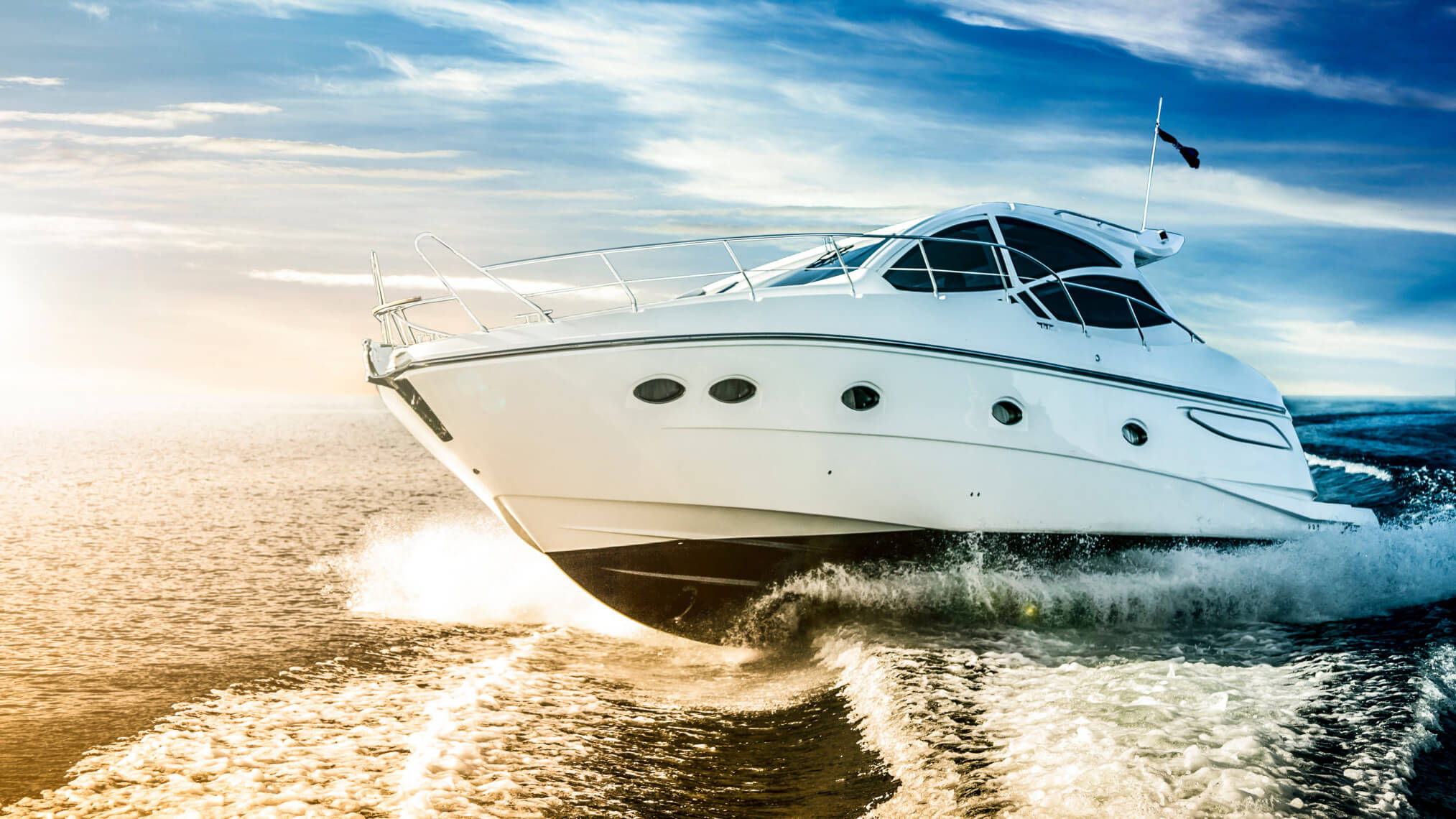 White yacht speeding across golden ocean